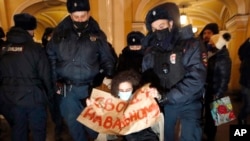 Russian police officers detain a woman on Jan. 18, 2021. 