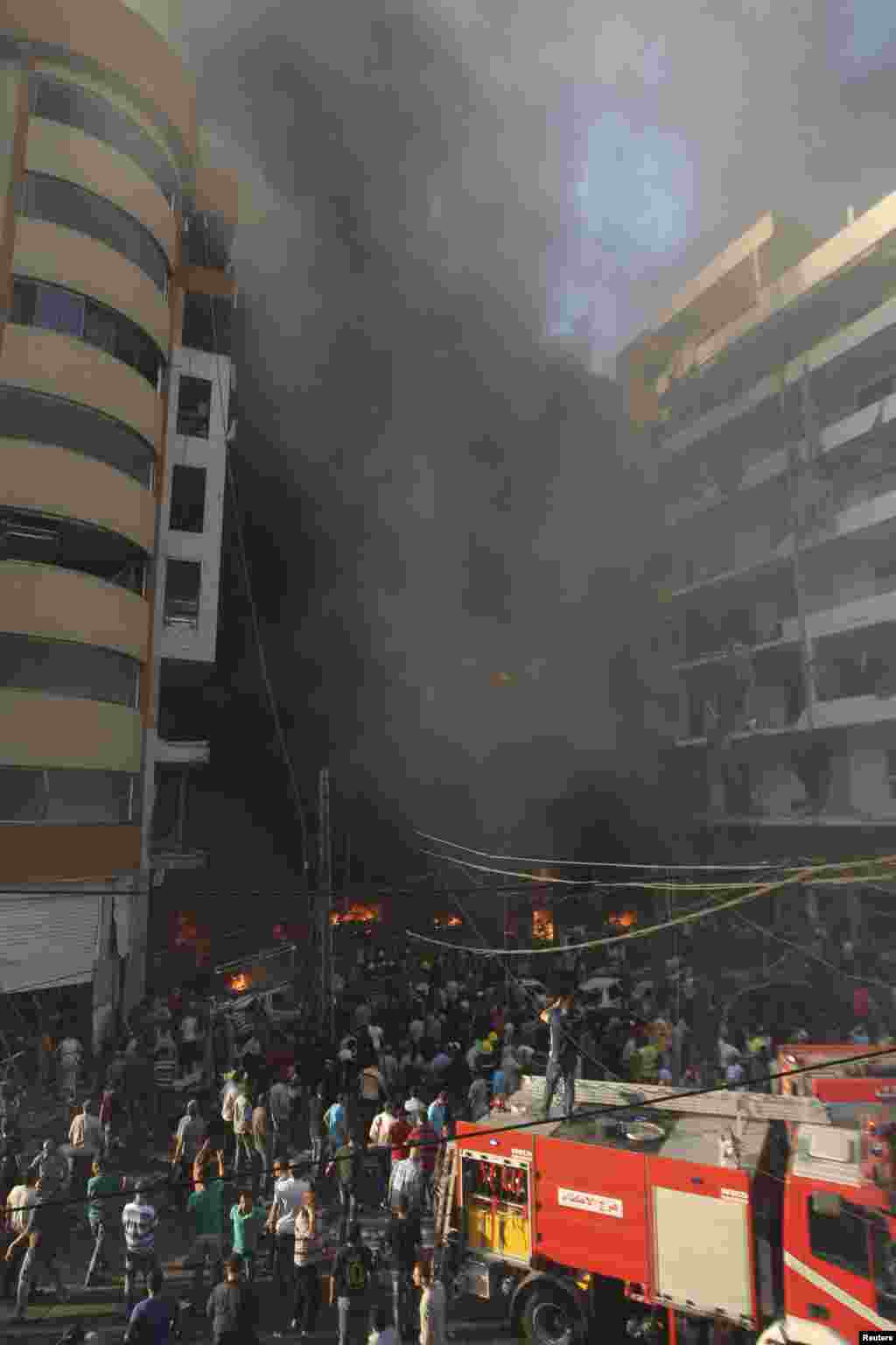 People gather around the site of an explosion in Beirut's southern suburbs, August 15, 2013.