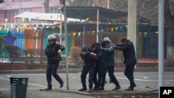 지난 6일 카자흐스탄 알마티에서 무장 경찰들이 반정부 시위 참가자들을 연행하고 있다.