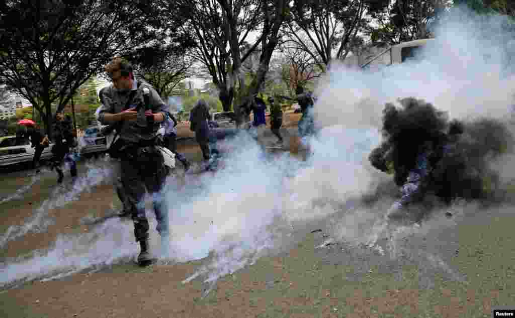케냐 수도 나이로비에서 정부의 부패와 공권력 남용에 항의하는 시위 도중 최루탄이 터지자, 현장을 취재하던 사진기자가 고개를 돌리고 있다.
