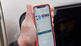 Precinct captain Carl Voss of Des Moines displays the Iowa Democratic Party caucus reporting app on his phone outside of the Iowa Democratic Party headquarters in Des Moines, Iowa, Tuesday, Feb. 4, 2020. (AP Photo/Nati Harnik)