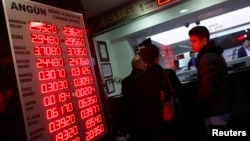 People check currency exchange rates at an currency exchange office in Istanbul, Dec. 16, 2014. 