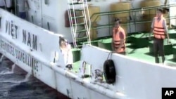 越南海岸警卫队公布的一张视频截图里，几名警卫队船员站在船的一侧。该船便是越南宣称在遭遇中国船只撞击后损坏的越南海岸警卫队船只（2014年5月7日）