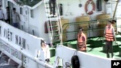 A Vietnamese surveillance ship's crew members stand near the side of the ship, allegedly damaged after being rammed by a Chinese ship, in the South China Sea, off Vietnam's coast, May 7, 2014.