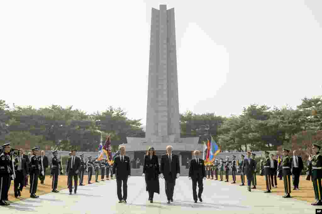 Presiden Donald Trump dan Ibu Negara Melania Trump berjalan untuk meletakkan karangan bunga di Pemakaman Nasional Korea Selatan, di Seoul, 8 November 2017.