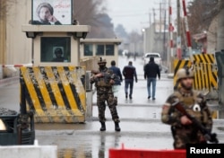 FILE - Afghan security forces keep watch at a check point near the site of a suicide attack in Kabul, Afghanistan, Feb. 24, 2018.