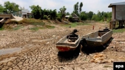 Two boats lie on cracked ground in a dry area in Ca Mau province, Vietnam, 18 April 2016. 