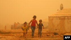 Anak-anak Suriah berjalan di tengah-tengah badai pasir yang melanda kemah penampungan pengungsi di Baalbek, Lebanon (Foto: dok). 