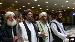 Mullah Abdul Ghani Baradar, pemimpin tertinggi kelompok Taliban (kiri kedua) tiba dengan anggota delegasi Taliban lainnya untuk mengadakan pembicaraan di Moskow, Rusia. (Foto: AP / Alexander Zemlianichenko)