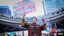 Seorang demonstran merantai dirinya dalam aksi unjuk rasa di Bangkok pada 14 November 2021, di mana massa berkumpul untuk menyerukan reformasi monarki di Thailand. (Foto: VOA/Tommy Walker)