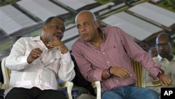 Haiti's President Michel Martelly (R) speaks with Haiti's Prime Minister Garry Conille at a ceremony on the outskirts of Cap Haitien, Haiti, November 28, 2011.