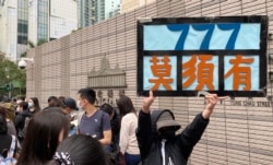 排队人士高举示威标语，抗议当局以莫须有罪名控告47名民主派人士 (美国之音/汤惠芸)