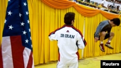FILE - An Iranian wrestler warms up beside an American flag before his match during the 2009 Takhti Free Style Wrestling Tournament in Tehran.