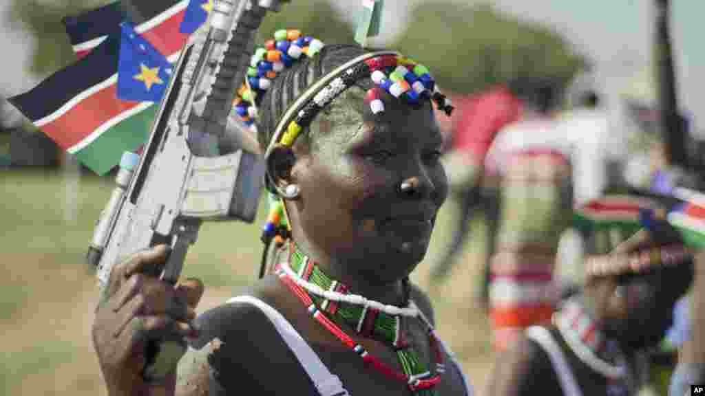Une femme sud-soudanaise porte le drapeau national et une arme lors de la cérémonie pour célébrer l'indépendance dans la capitale Juba, 9 juillet 2015.