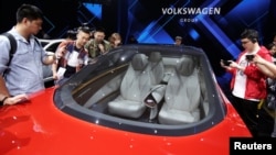 Journalists visit a Volkswagen I.D. concept car at a media event ahead of the Beijing Auto Show in Beijing, China April 24, 2018. 