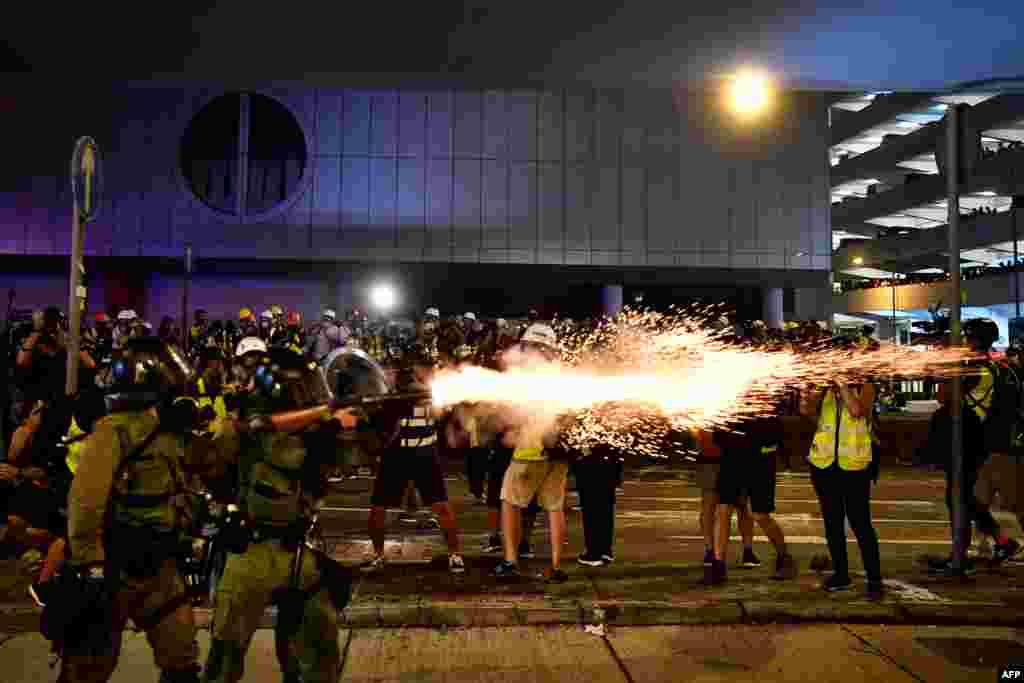 A policeman fires tear gas at protesters to disperse them after a march against a controversial extradition bill in Hong Kong.