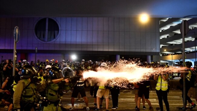 2019年7月21日，香港一名警察向“反送中”抗议者喷射催泪瓦斯。