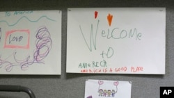 Children's drawings that read "Welcome to America, America is a good place," are displayed, April 24, 2017, at a Jewish Family Service Refugee and Immigrant Service Center in Kent, Washington, during a visit by Washington Gov. Jay Inslee. 