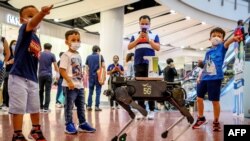 Timoun ki t ap jwe apre yo te fin resevwa kachne ak dezenfektan pou yo lave men yo nan yon shopping center nan vil Bannkok, peyi Taylann, nan kad yon kanpay pou konbat pwopagasyon KOVID-19 la. (Foto: Mladen ANTONOV / AFP).