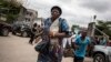 A Congolese woman runs for cover after police fired warning shots to disperse a crowd at the end of a Catholic service that commemorates the victims of a crackdown on last month's march on Jan. 12, 2018 in Kinshasa.