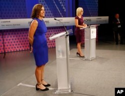 FILE - U.S. Rep. Martha McSally, R-Ariz., left, and U.S. Rep. Kyrsten Sinema, D-Ariz., prepare their remarks in a television studio prior to a televised debate, Oct. 15, 2018, in Phoenix. They're running for the U.S. Senate seat being vacated by Republican Jeff Flake.