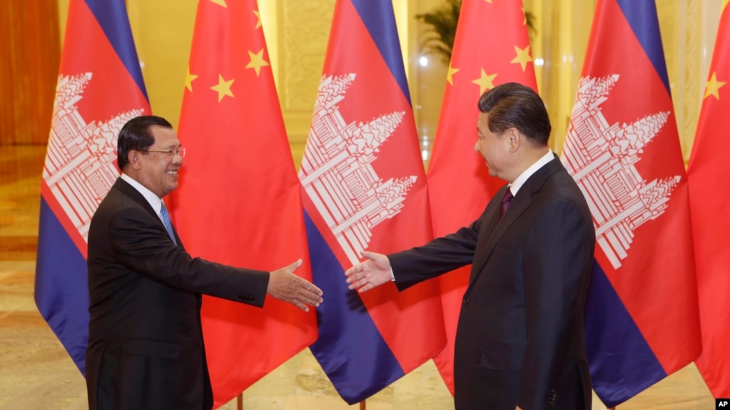 Cambodian Prime Minister Hun Sen, left, shakes hands with China's President Xi Jinping before a meeting at the Great Hall of the People in Beijing Friday, Nov. 7, 2014. (AP Photo/Jason Lee, Pool)