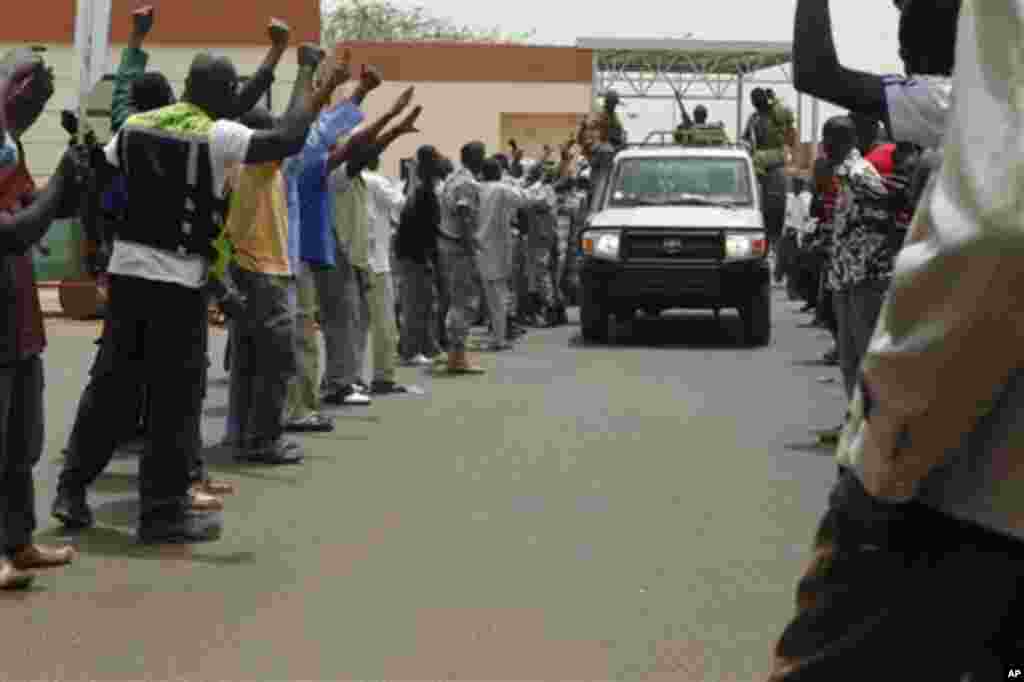 People supporting the recent military coup cheer as the convoy carrying coup leader Capt. Amadou Haya Sanogo leaves the airport in Bamako, Mali Thursday, March 29, 2012.
