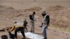 Para karyawan Kementerian Kesehatan Irak mengumpulkan kerangka orang-orang yang menurut pejabat Irak, dibunuh oleh militan ISIS, dalam penggalian kuburan massal di Mosul, Irak, Minggu, 13 Juni 2021. (Foto: Abdullah Rashid/Reuters) 