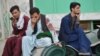 Afghan men sit in a courtyard inside a Shiite mosque in Kandahar on Oct. 15, 2021, after a suicide bomb attack during Friday prayers that killed more than 30 people. 