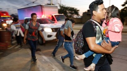 U.S.-bound migrants walk along the roadside as they leave San Pedro Sula, Honduras, at dawn Tuesday, Jan. 15, 2019. Yet another caravan of Central American migrants set out overnight from Honduras, seeking to reach the U.S. border, following the same rout