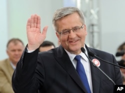 FILE - Polish President Bronislaw Komorowski greets supporters during a meeting in Warsaw, May 8, 2015.