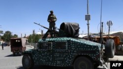 Les forces de sécurité afghanes patrouillent le long d'une route dans la ville de Ghazni, Afghanistan, le 14 août 2018,