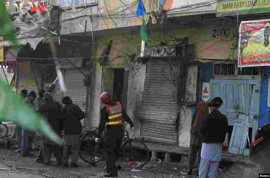 Security officials and rescue workers survey the site of a suicide blast in Rawalpindi, Pakistan, Jan. 20, 2014. 