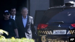 Jose Dirceu, ancien chef de cabinet de Lula, au centre, est escorté par des agents de la police fédérale à Brasilia, le 4 août 2015.