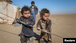 Internally displaced Syrian children who fled Raqqa city stand near their tent in Ras al-Ain province, Syria, Jan. 22, 2017. UNICEF is earmarking $1.4 billion to go toward helping 17 million children and families caught up in war inside Syria and living as refugees in five neighboring countries.