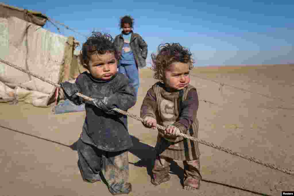 Internally displaced Syrian children who fled Raqqa city stand near their tent in Ras al-Ain province, Syria, Jan. 22, 2017.