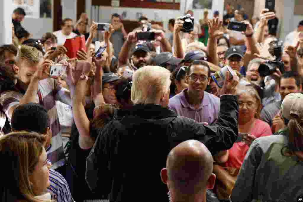 President Donald Trump hands out canned goods and other supplies at Calvary Chapel, Oct. 3, 2017, in Guaynabo, Puerto Rico.