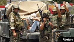 Lebanese army soldiers gesture as they capture a gunman in Sidon, southern Lebanon, June 24, 2013.