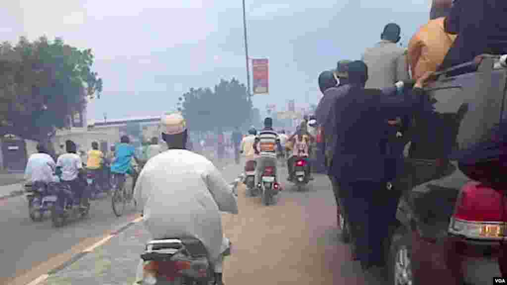People on motorbikes follow Al-Mustapha as he arrives in Kano.