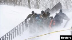 Tentara Pasukan Bela Diri Jepang membawa korban salju longsor yang menghantam sekelompok siswa SMA dan guru saat melakukan pendakian gunung dekat sebuah resor ski di kota Nasu, utara Tokyo, Jepang, 27 Maret 2017. (Foto: Kyodo/ Nasu via REUTERS).