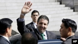 U.S. Ambassador to South Korea Mark Lippert, surrounded by security men, waves as he leaves Seoul's Severance Hospital in Seoul, South Korea, March 10, 2015.