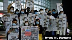 Staff members of Apple Daily and its publisher Next Digital pose with the final edition of Apple Daily at its headquarters in Hong Kong, China June 24, 2021. (REUTERS/Tyrone Siu)