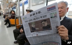 一位乘客在南韓首爾的地鐵列車上閱讀報導北韓領導人金正恩與美國總統唐納德·川普計劃舉行高峰會議的報紙。 （2018年3月10日）