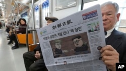 Một hành khách đọc báo với hàng tít về một cuộc họp thượng đỉnh giữa lãnh tụ Triều Tiên Kim Jong Un và TT Mỹ Donald Trump, trái, tại một trạm metro ở Seoul, Hàn quốc, ngày 10/3/2018.