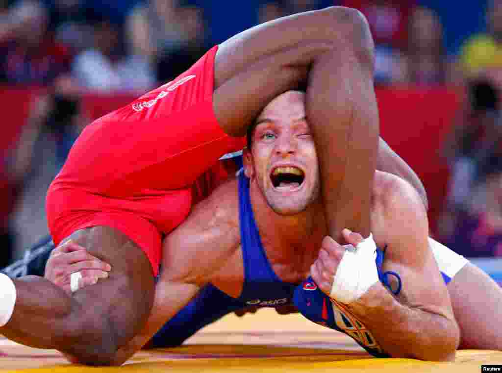 Jordan Ernest Burroughs of the U.S. (in red) fights with Canada's Matthew Judah Gentry in the Men's 74kg Freestyle wrestling.