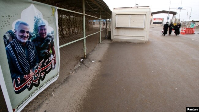 FILE - A poster with a picture of a martyr, member of Shiite Popular Mobilization Forces with Iranian Revolutionary Guard Commander Qassem Soleimani is seen at Iraqi side of the Shalamcha Border Crossing, Iraq, Nov. 4, 2018.