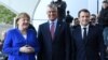 German Chancellor Angela Merkel, left, and French President Emmanuel Macron, right, welcome Kosovo's President Hashim Thaci, center, to a meeting with Western Balkans leaders, at the Chancellery in Berlin, Germany, April 29, 2019.