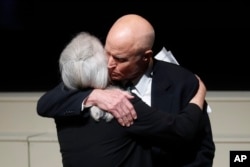 John David Glenn hugs his sister, Carolyn Ann, after they spoke at their father John Glenn's funeral in Columbus, Ohio, Dec. 17, 2016.