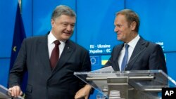 ປະທານາທິບໍດີຢູເຄຣນ ທ່ານ Petro Poroshenko (ຊ້າຍ) ໂອ້ລົມກັບປະທານສະພາຢູໂຣບ ທ່ານ Donald Tusk ກ່ອນ ການຖະແຫຼງຂ່າວ ໃນຕອນປິດ ກອປະຊຸມສຸດຍອດ ສະຫະພາບຢູໂຣບກັບຢູເຄຣນ. (24 ພະຈິກ 2016)