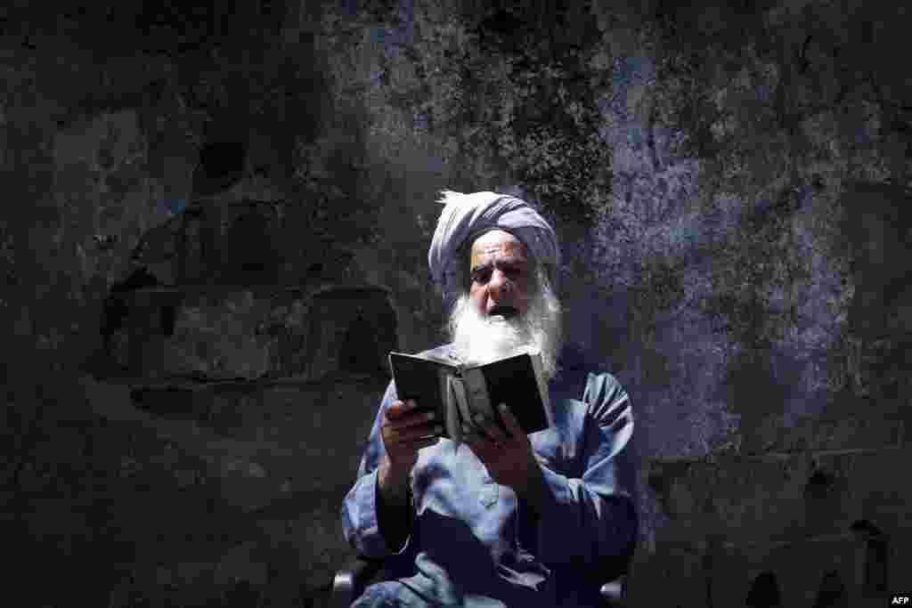 A Palestinian man reads the Quran during the holy month of Ramadan in Gaza City.